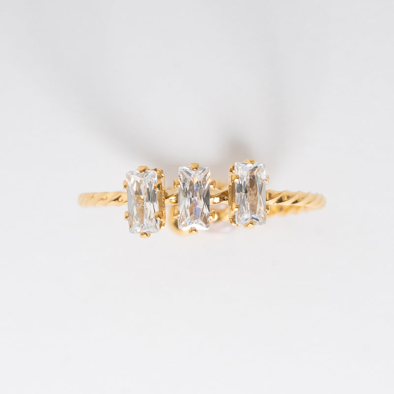 Anillo dorado de forma trenzada con zirconias de forma rectangular