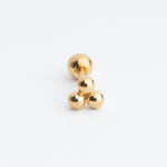 Piercing dorado con bolitas en forma de triángulo